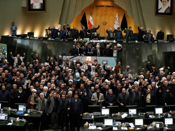 Iranian lawmakers chant slogans as some of them hold posters of Gen. Qassem Soleimani, who was killed in Iraq in a U.S. drone attack, in an open session of parliament, in Tehran, Iran, Tuesday, Jan. 7, 2020.