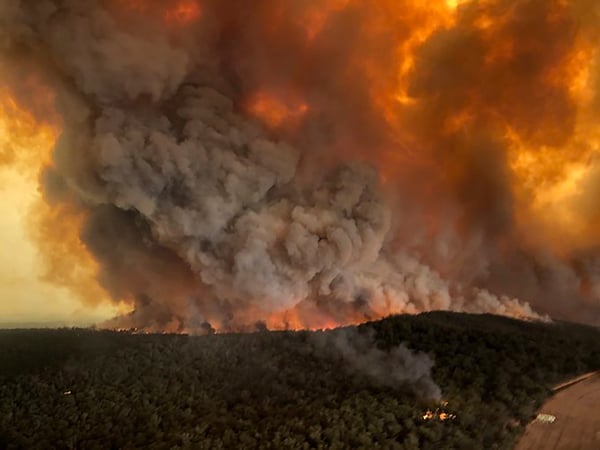 In this Monday, Dec. 30, 2019, aerial photo, wildfires rage under plumes of smoke in Bairnsdale, Australia.