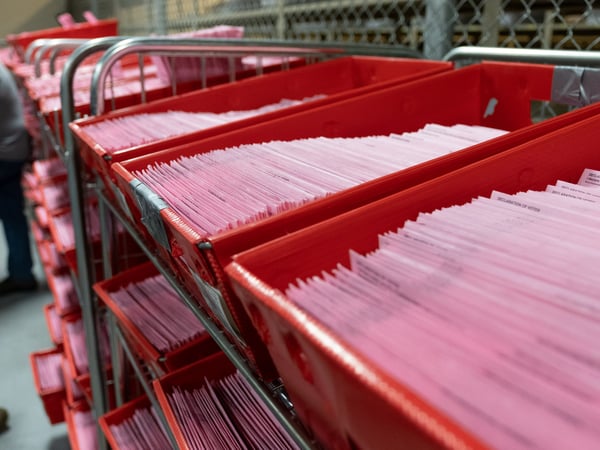 Vote-by-mail ballots wait to be opened at the county registrar's office March 3, 2020.