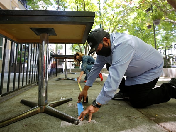 Francisco Medina, manager of Tequila Museo Mayahuel restaurant, measures the distance between tables for social distancing in the outdoor dining space in Sacramento, Calif., Wednesday May 20, 2020.