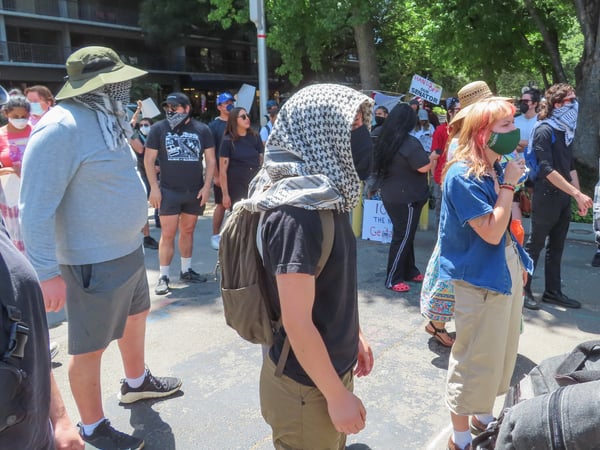 Protesters look at a van allegedly holding at least one immigrant detainee Thursday, June 12, 2025, outside of the John Moss Federal Building at 650 Capitol Mall in Sacramento. They blocked the exits to make sure the van couldn't leave.