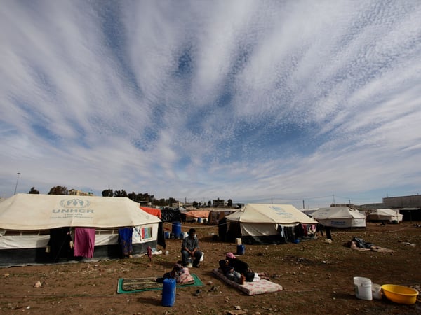 Refugees take a rest outside their tents at an unofficial refugee camp on the outskirts of Amman, Jordan, Wednesday, Jan. 22, 2014.