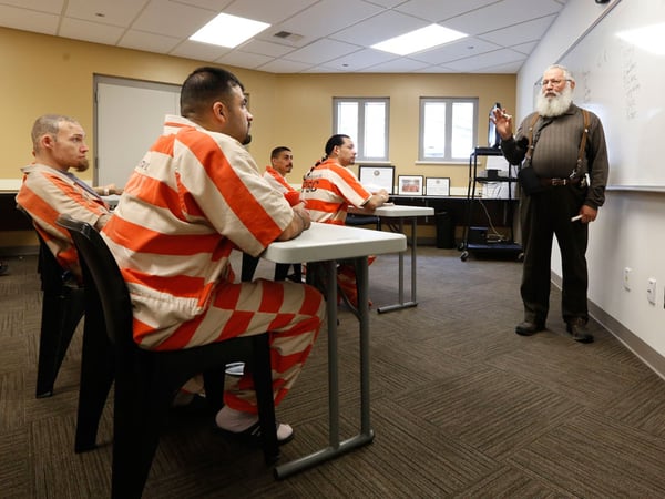 In this March 25, 2014 photo, Michael Atinsky, right, leads a discussion group for inmates at the new 192-bed facility at the Stanislaus County Jail in Modesto, Calif. 