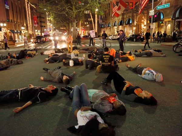 Protesters lie down on a street in Beverly Hills, Calif., Tuesday, Nov. 25, 2014, after the announcement of the grand jury decision not to indict Ferguson police Officer Darren Wilson in the fatal shooting of Michael Brown, an unarmed 18-year-old. 
