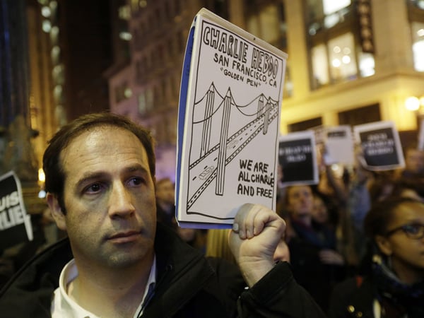 Regis Denon, of Paris, France, holds a sign in remembrance at a gathering in solidarity with those killed in an attack at the Paris offices of the weekly newspaper Charlie Hebdo on Wednesday, Jan. 7, 2015.