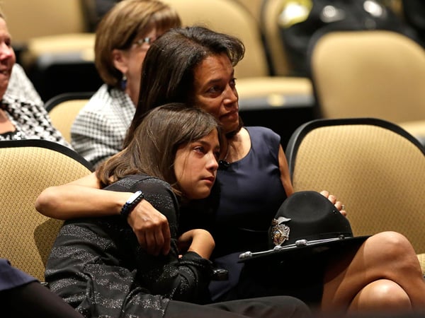 Susan Oliver, the wife of slain Sacramento County Deputy Danny Oliver, comforts their daughter, Jenny 11, during a memorial service in Roseville, Calif. Monday, Nov. 3, 2014. 