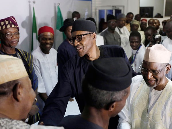 Nigerian former Gen. Muhammadu Buhari, center, shakes hands with party officials after speaking to journalists in Abuja, Nigeria, Wednesday, April 1, 2015. 