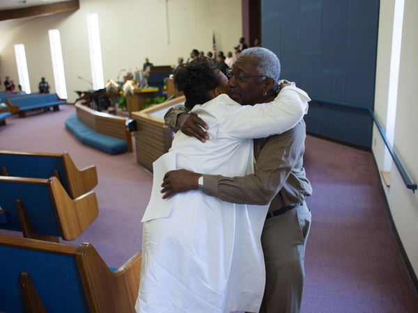 Orville W. Noel Jr hugs a fellow parishioner after delivering a speech at Allen Chapel Sunday. It was the first Sunday service since the Wednesday shooting at an AME church in Charleston, S.C.
