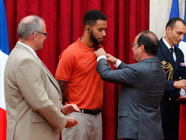 French President Francois Hollande, right, awards with the Legion of Honor Anthony Sadler, a senior at Sacramento State as British businessman Chris Norman, left, looks on at the Elysee Palace, Monday Aug.24, 2015 in Paris, France.