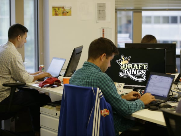 In this Wednesday, Sept. 9, 2015, photo, Bear Duker, a marketing manager for strategic partnerships at DraftKings, a daily fantasy sports company, works at his computer in Boston.  