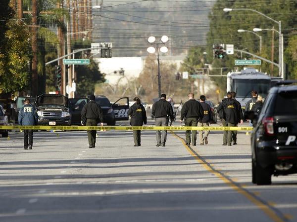 Investigators search for bullet casings at the scene where Wednesday's police shootout with suspects took place, Thursday, Dec. 3, 2015, in San Bernardino, Calif. 