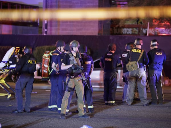 Police officers and medical personnel stand at the scene of a shooting near the Mandalay Bay resort and casino on the Las Vegas Strip, Monday, Oct. 2, 2017. Multiple victims were being transported to hospitals after a shooting late Sunday.