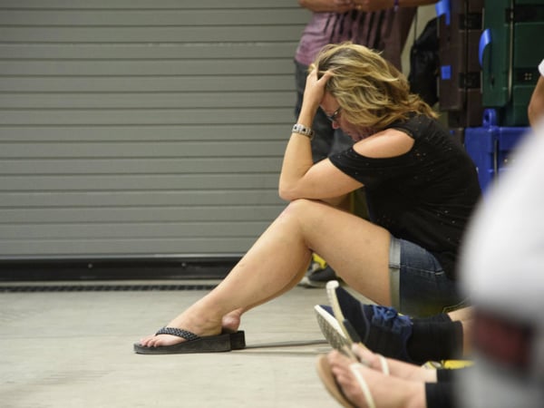 A young woman hides inside the Sands Corporation plane hangar after a gunman opened fire at the Route 91 Harvest Festival on Sunday, Oct. 1, 2017, in Las Vegas.
