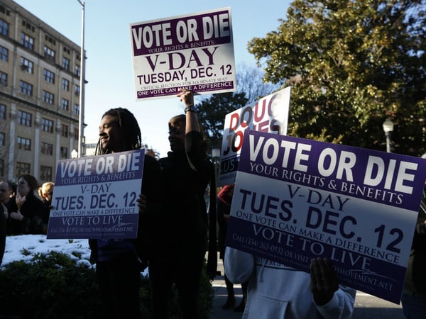 Supporters stand outside encouraging for people to vote after Democratic senatorial candidate Doug Jones spoke at a campaign rally Sunday, Dec. 10, 2017, in Birmingham, Ala.