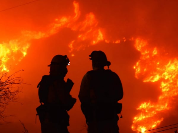 In this early morning Sunday, Dec. 10, 2017 photo released by Santa Barbara County Fire Department, firefighters working on structure protection, keep a close eye on nearby flames atop Shepard Mesa Road in Carpinteria, Calif. 