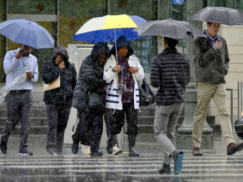 Pedestrians make their way across a street in the pouring rain in downtown Los Angeles on Wednesday, March 21, 2018. The storm came ashore on the central coast and spread south into the Los Angeles region and north through San Francisco Bay.