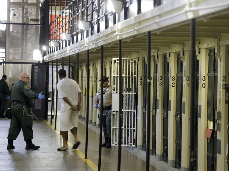 In this Aug. 16, 2016, file photo a condemned inmate is led out of his east block cell on death row at San Quentin State Prison, in San Quentin, Calif. 