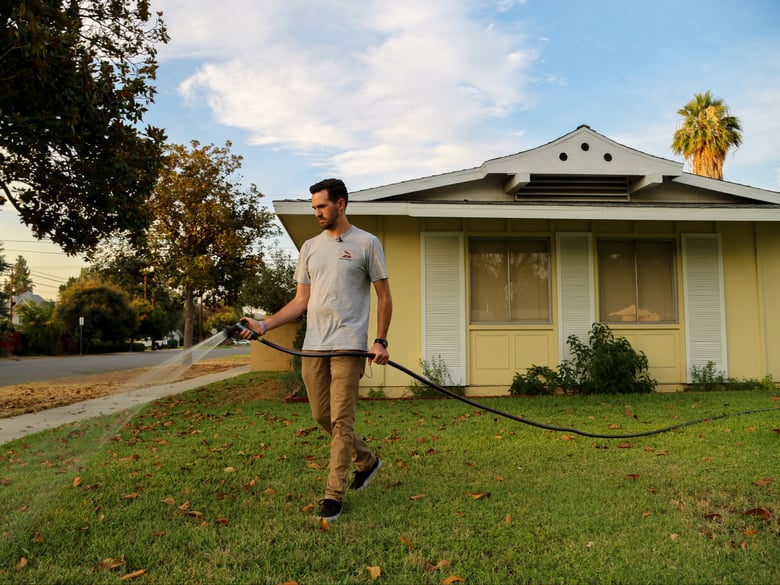 Brandon Miller waters the lawn in front of his Riverside home, July 17, 2018. 