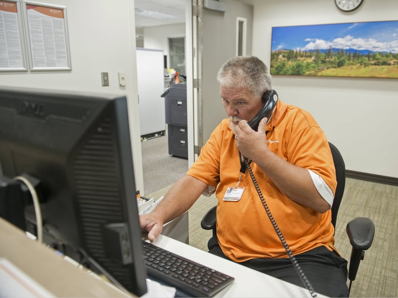 Robert Tierney Jr., right, a patient registration specialist at Mercy Medical Center, who lost his home in the recent fires, works at his job in Redding, Calif., Thursday, Aug. 2, 2018.