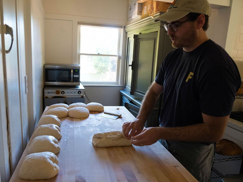 Christopher Beattie shapes sourdough loaves prior to baking them in his Sacramento home. 