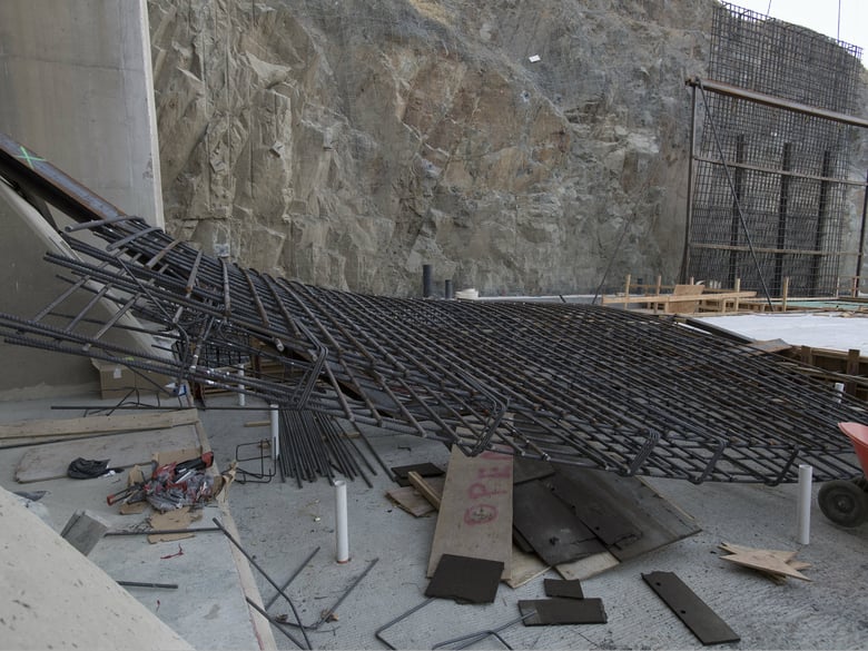 The diagonal steel braces like those seen on the structure in the back were inadequate to hold the temporary rebar structure in place. 