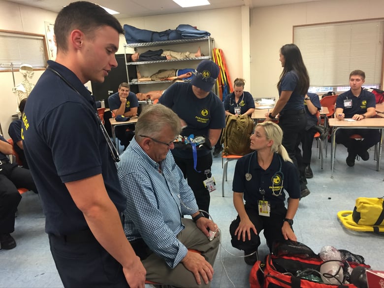 Brandon Faddis leads classmates during a simulated call as instructor Grant Goold plays the part of a patient.