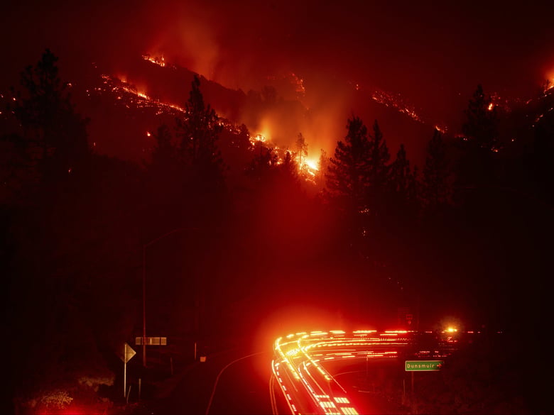 Fire trucks pass the Delta Fire burning in the Shasta-Trinity National Forest, Calif., on Wednesday, Sept. 5, 2018. Parked trucks lined more than two miles of Interstate 5 as both directions remained closed to traffic.