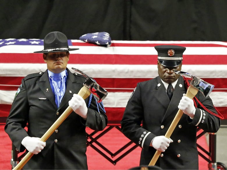 The Honor Guard stands at attention in front the casket of Battalion Chief Matt Burchett of the Draper Fire Department during funeral services Monday, Aug. 20, 2018, in West Valley City, Utah.