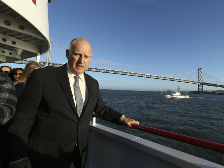 Gov. Jerry Brown walks to the bow of the high-tech battery-operated San Francisco Bay sightseeing boat, Enhydra. He signed 16 new laws aimed at easing global warming Sept. 13, 2018.