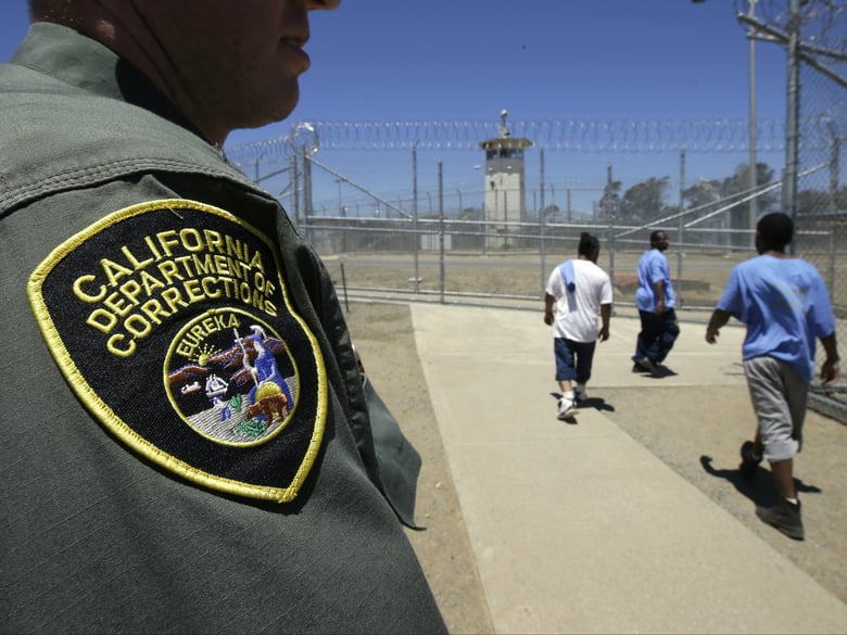 In this June 20, 2018 file photo, inmates pass a correctional officer as they leave an exercise yard at the California Medical Facility in Vacaville, Calif.