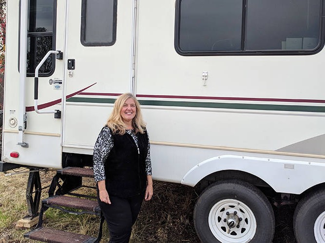 Kelley Conner stands outside the used RV she bought after the Camp Fire destroyed her home in Magalia, just north of Paradise, California.