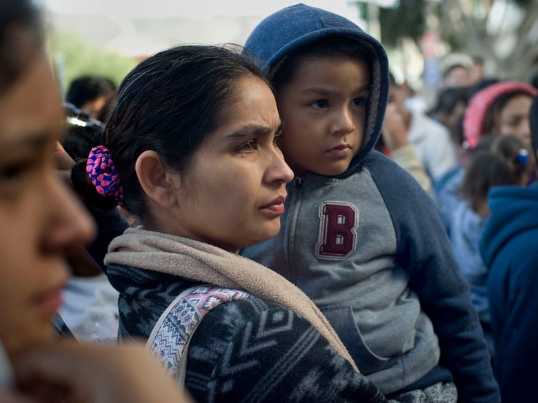A woman and child in Tijuana, Mexico, wait to hear their position on a list of people hoping to seek asylum in the U.S. on Nov. 21, 2018.