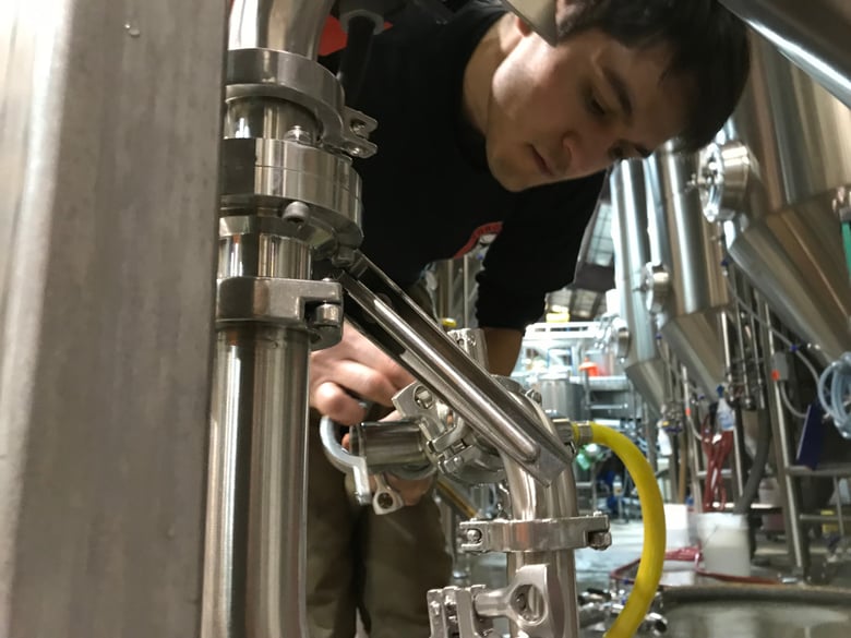 Trevor Williamson cleans the brewing equipment at Fifty Fifty Brewing Company. Owners Alicia Barr and her husband, Andrew Barr, ditched their jobs at Hewlett-Packard a dozen years ago to move to the mountains and start the brewery.
