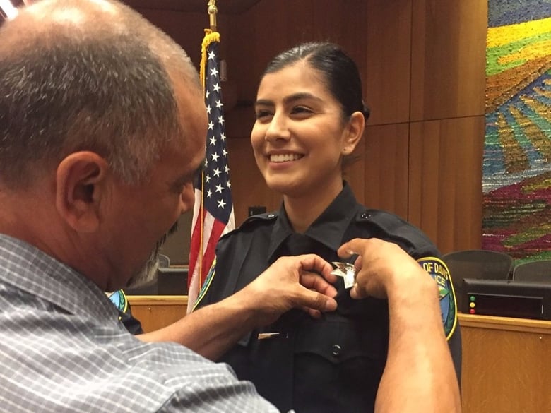 Merced Corona (left), pins his daughter, Natalie Corona's badge on her during a swearing-in ceremony in the City of Davis on Aug. 2. Officer Corona was shot and killed Jan. 11, 2019.