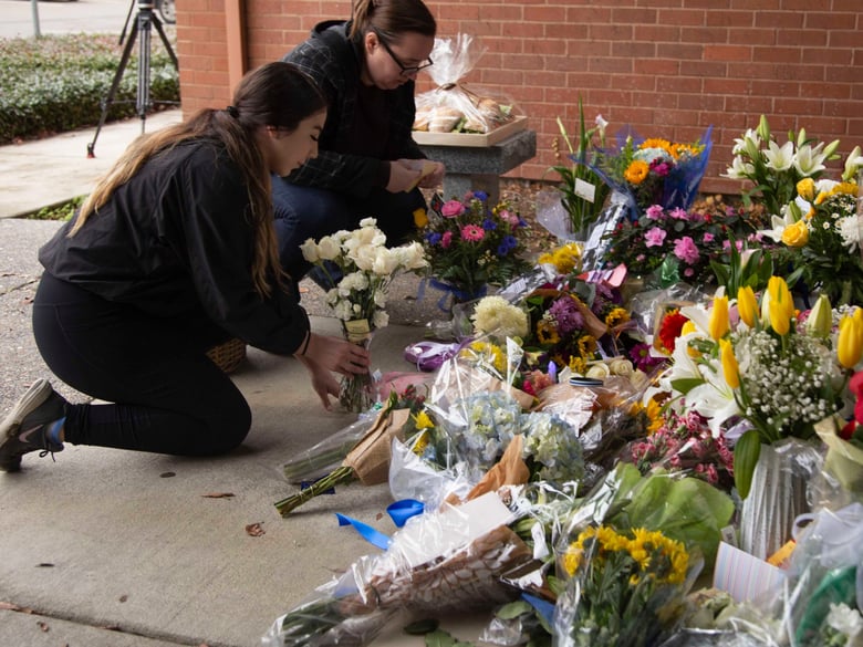 Hannah Leyva and Celina Alvaraz lay flowers outside the Davis Police Department after the death of Officer Natalie Corona.