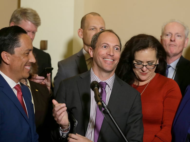 Assemblyman Brian Maienschein, center, smiles at a news conference where he announced he was switching party registration from Republican to Democrat, Thursday, Jan. 24, 2019, in Sacramento, Calif.
