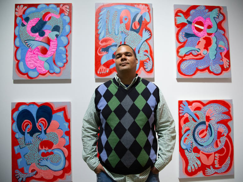 Artist Tavarus Blackmon in front of red-and-blue stereoscopic prints featured in his “Exquisite Diversion” show.