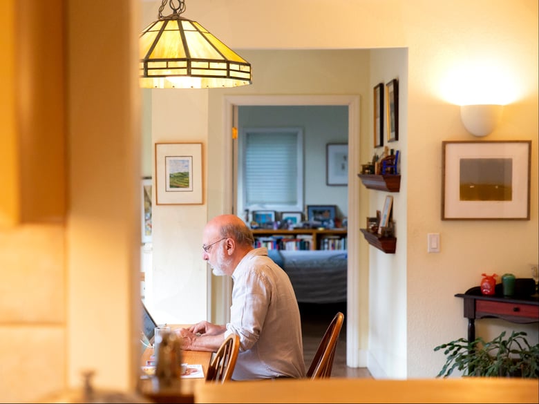 Retired University of California scientist Ed Vine works on his computer in his Berkeley home. The university is recruiting older homeowners to open their homes to students.