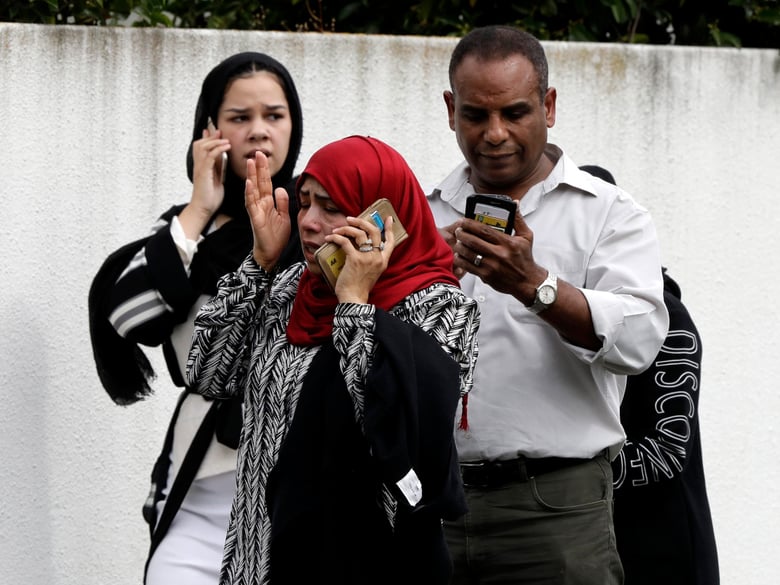 People wait outside a mosque in central Christchurch, New Zealand, Friday, March 15, 2019. Many people were killed in a mass shooting at a mosque, a witness said.