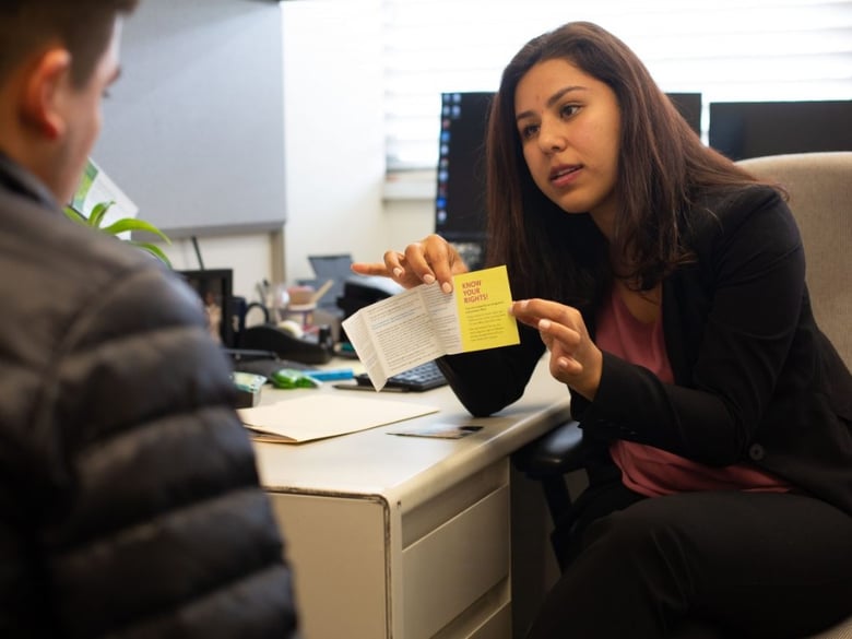 Karina Gutierrez, an immigration lawyer on the UC Riverside campus, helps the brother of a student understand his rights.