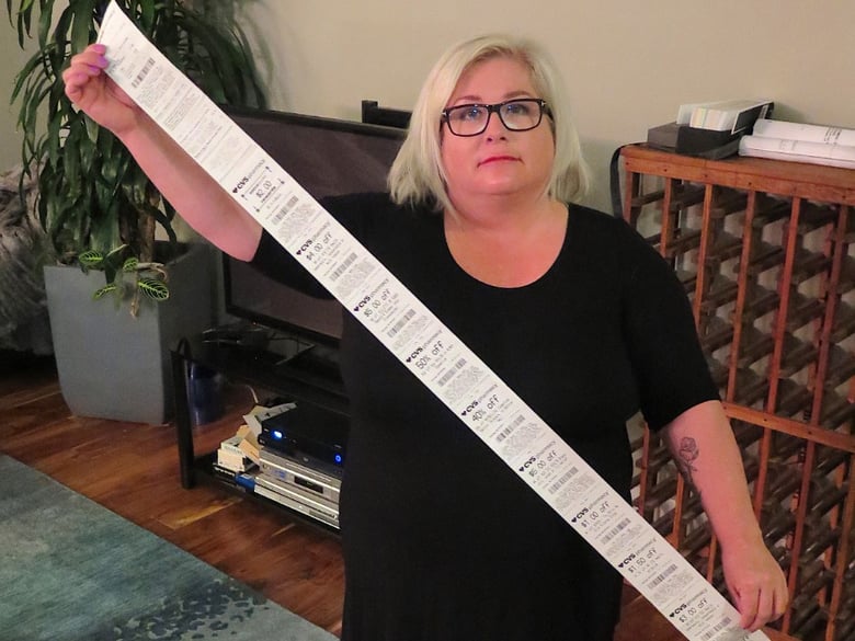 Carol Dahmen poses with a receipt that's more than 4 feet long—for the purchase of a single item.