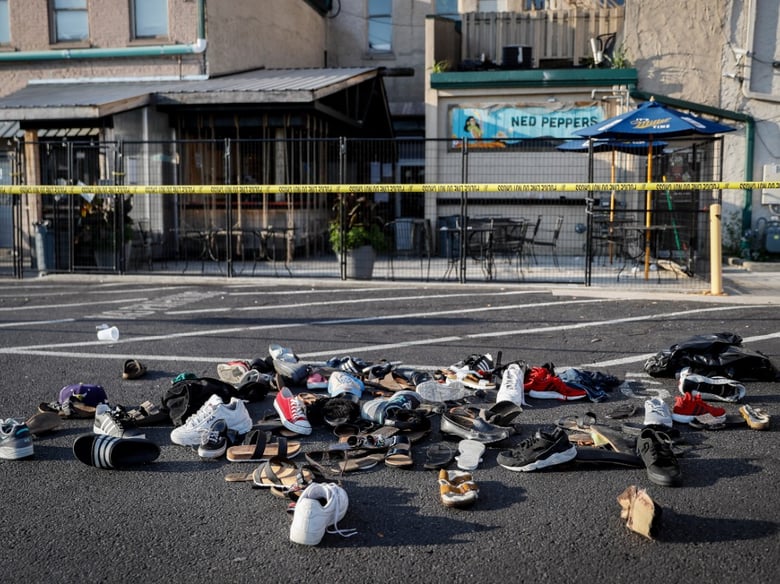Shoes are piled outside the scene of a mass shooting including Ned Peppers bar, Sunday, Aug. 4, 2019, in Dayton, Ohio. Several people in Ohio have been killed in the second mass shooting in the U.S. in less than 24 hours.