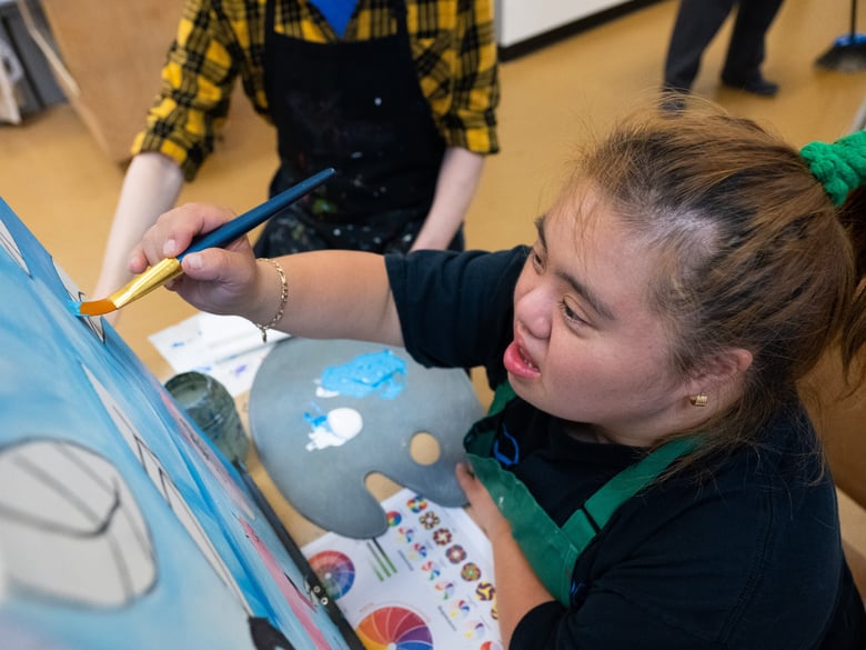 Eva Kimjun paints at Southside Unlimited, a program offering arts activities to disabled adults.