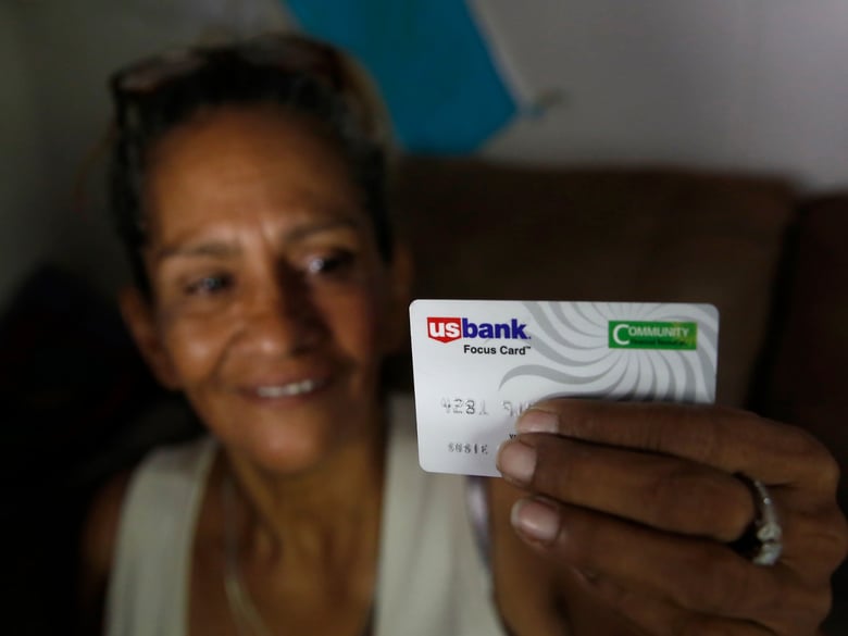 Susie Garza displays the city provided debit card she receives monthly through a trial program in Stockton, Calif. Garza is participating in the Stockton Economic Empowerment Demonstration.