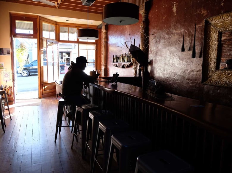 A patron sits at Szabo Vineyards Tasting Room in historic Nevada City with the lights off following the PG*E power shut off.