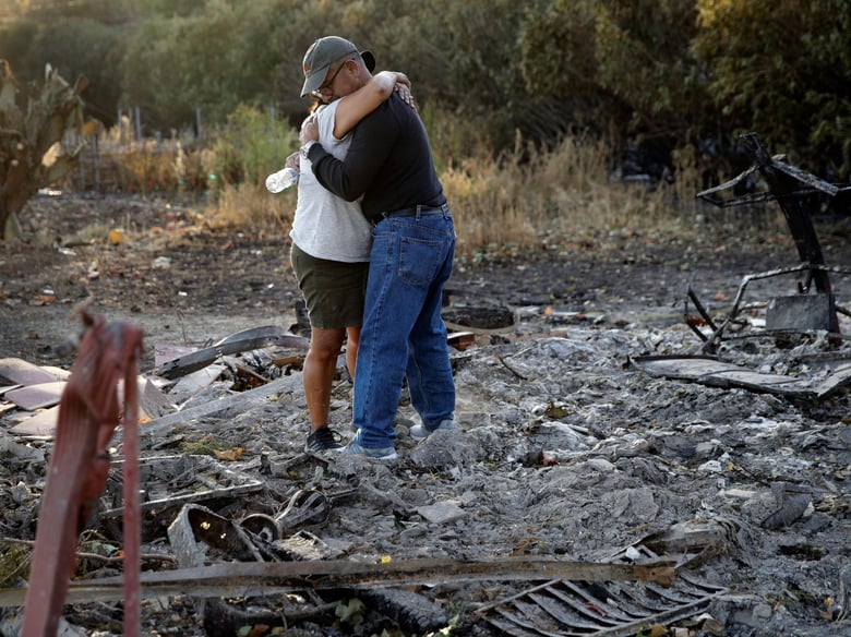 Justo and Bernadette Laos hug while looking through the charred remains of the home they rented that was destroyed by the Kincade Fire near Geyserville, Calif., Thursday, Oct. 31, 2019.