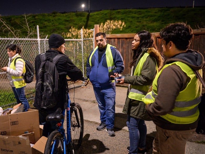 Homeless survey volunteers gather survey information from homeless people living in the Lowell neighborhood of Fresno during the January annual point-in-time homeless count.