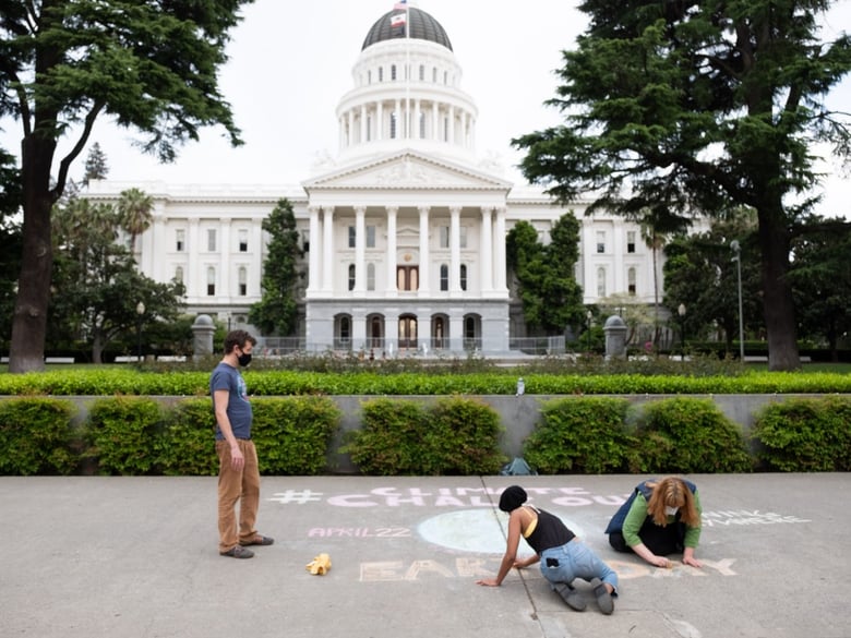 Wes Samms, Mikayla Taylor and Zuzu Schmitke wrap up their chalk art along 10th Street by the Capitol Wednesday, April 15, 2020.