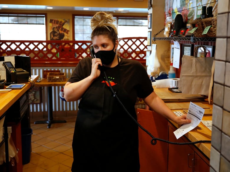 Stephanie Stoehr takes a call for a takeout order at the Dancing Tomato Caffe, in Yuba City, Calif., Tuesday, May 12, 2020.