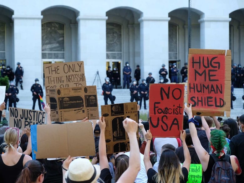 Protesters demonstrating against the killing of George Floyd by Minneapolis police take a knee near the east steps of the California state Capitol as police stand on June 3, 2020.